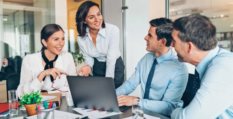 Quatro profissionais conversando em uma reunião de trabalho